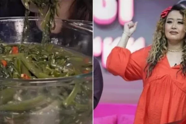 Pinkan Mambo tersenyum memegang sepiring tumis kangkung dengan label harga Rp150.000, di dapur.